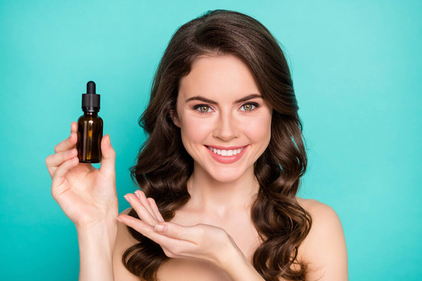 Closeup photo of beautiful naked lady wavy long hairdo hold professional cure serum bottle oil treatment cosmetologist specialist advising buy product isolated teal color background - Photo, image