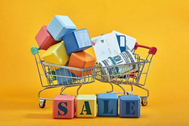different colored blocks with the wordings SALE, isolated against yellow background. - Foto, Imagem