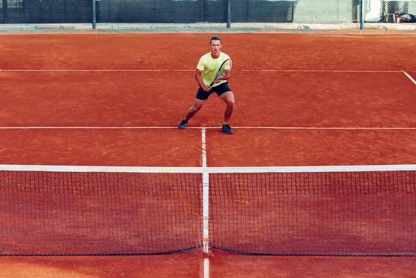 Young handsome man playing tennis on the tennis court - Φωτογραφία, εικόνα