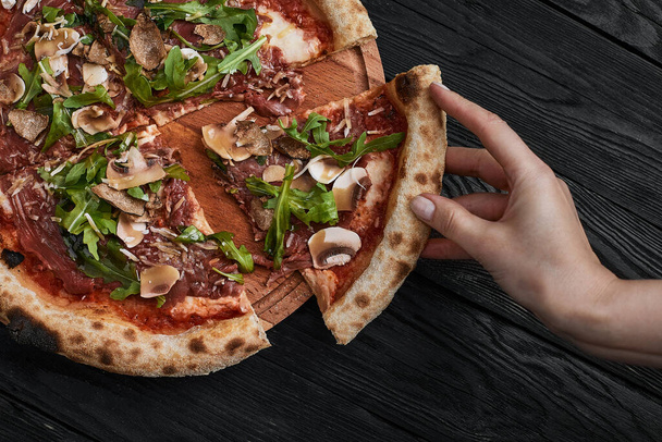 Close up on delicious freshly baked small pizza with melted cheese mushrooms and arugula - Fotoğraf, Görsel