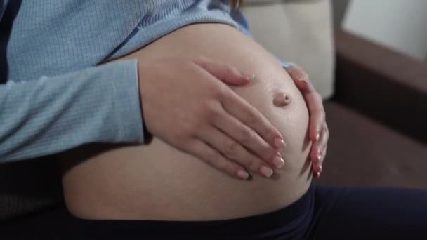 A női kezek közelsége egy terhes nő hasát nézi. A béranya fogalma - Felvétel, videó