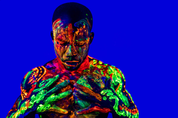 afro american man with UV body art posing in studio - Fotó, kép