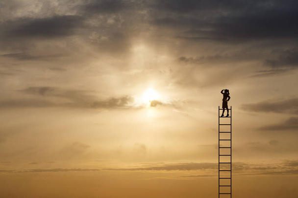 Concepto de perspectiva empresarial. Mujer de negocios se para en las escaleras y mira a la distancia contra el telón de fondo de una puesta de sol soleada. - Foto, Imagen
