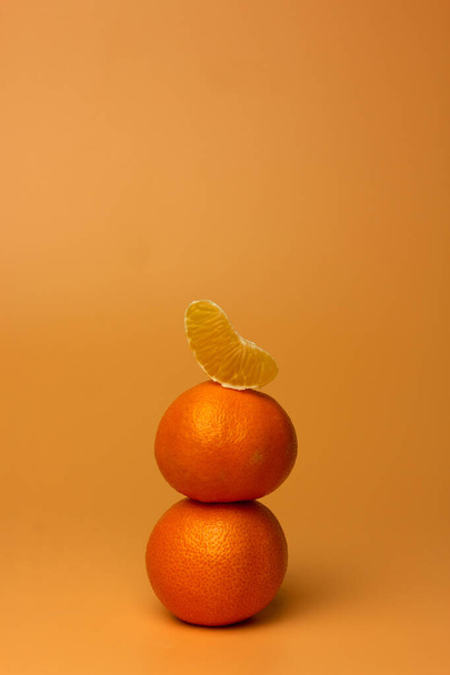 Composición creativa de mandarinas y rodajas sobre un fondo amarillo. Estilo de vida saludable. Minimalismo. Colocación plana, espacio de copia. - Foto, imagen