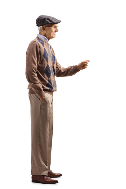 Full length profile shot of an elderly gentleman gesturing with hand and smiling isolated on white background - 写真・画像