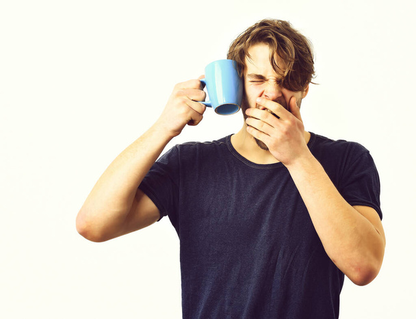 Caucasian sexy young macho holding coffee cup or mug - Foto, imagen
