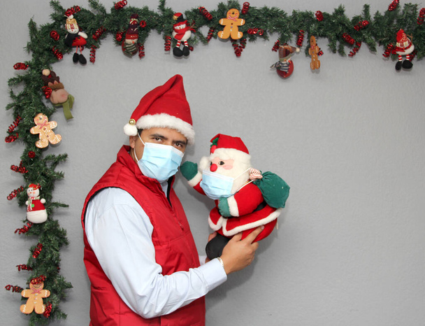 latino mies suojelu naamio ja joulupukki nukke joulukoristeena, uusi normaali covid-19 - Valokuva, kuva