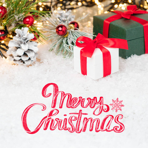 Весела різдвяна листівка з подарунковими коробками та червоною стрічкою на снігу
. - Фото, зображення