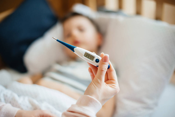 Thermometer close- up during the child's illness . The virus and the epidemic - 写真・画像