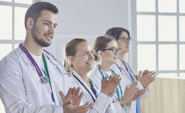 Szczęśliwy zespół medyczny składający się z mężczyzn i kobiet lekarzy uśmiechających się szeroko i dając kciuki w górę sukcesu i nadziei - Zdjęcie, obraz