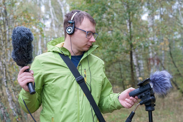 The guy with myerophne and headphones is recording the sounds of nature. Recording Ambient Sounds - Photo, Image