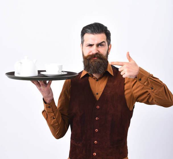 Barman with serious face in uniform serves coffee or tea. - Foto, Bild