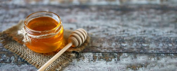 Miel en un frasco. Apégate a la miel. Dulzura saludable. Producto apícola. - Foto, imagen