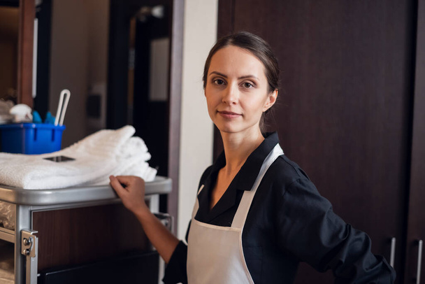 Hotel housekeeper pushing a cleaning supply cart - Photo, Image