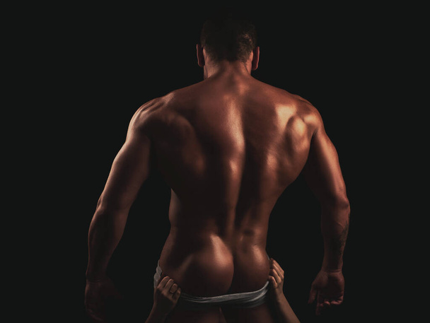 Panties off. Mens underwear undress. Naked sexy man with strong body and bare torso. Muscular back. Fashion brutal guy with sexy back. Mens ass and powerful shoulders. Undressed handsome dominant gay. - Zdjęcie, obraz