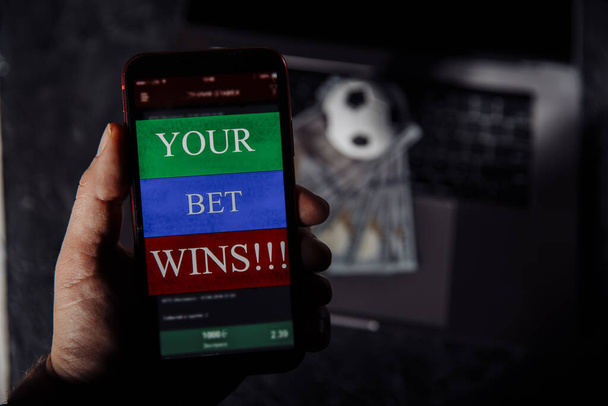携帯電話を手にサッカーの賭けで幸運な勝者。賭けとスポーツの概念 - 写真・画像