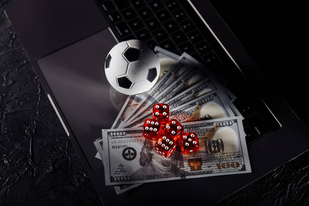 Dice, soccer ball and dollar banknotes on keyboard. Gambling and betting concept - Photo, Image