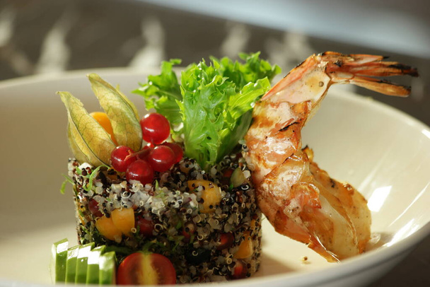 Салат из киноа с овощами и хвостом омара. - Фото, изображение