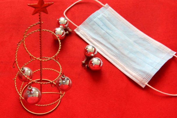 silver christmas star and spheres with protection mask on red background, christmas new normal covid-19 - Photo, Image