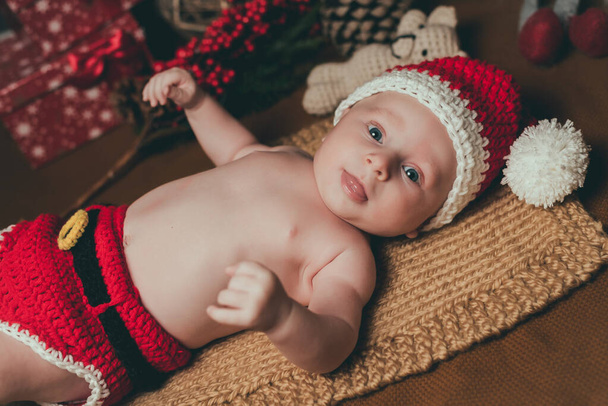 Amazed attractive baby boy in Christmas costume crawling - Foto, Imagen