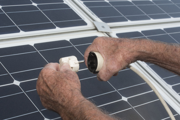 электрическая розетка и солнечная панель, устойчивое и экологическое производство энергии - Фото, изображение
