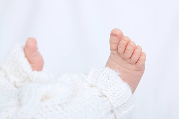 Newbornfeet baby in cotton pants on white background - Φωτογραφία, εικόνα