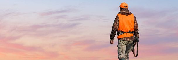 Silhouette eines Jägers mit einem Gewehr gegen die Sonne, ein Hinterhalt für Enten. - Foto, Bild