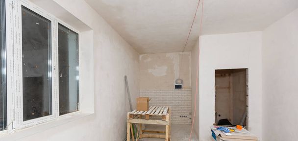 Ремонт у будинку. Дерев'яний стіл для ремонту, штукатурки і фарбування стін в кімнаті
 - Фото, зображення