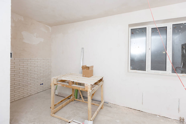 Reparación en la casa. Mesa de madera para reparar, enlucir y pintar las paredes de la habitación - Foto, Imagen