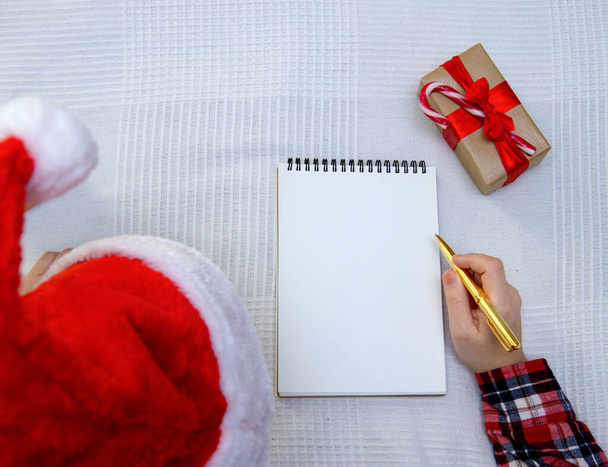  child writes letter to Santa and there is box with gift nearby - Foto, Imagen