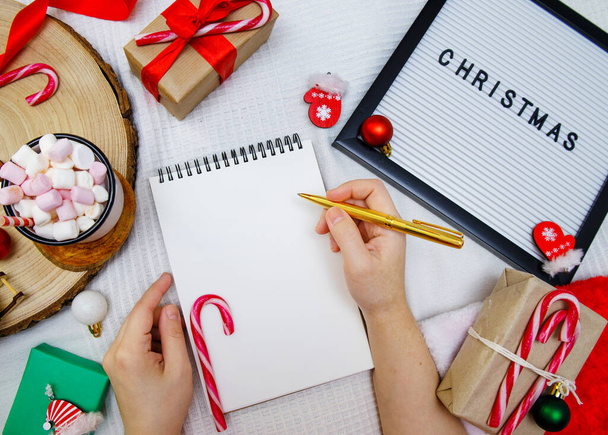 hands hold a pen and a notebook to write a letter to Santa - Foto, Imagem