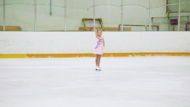 Ragazzina che pratica pattinaggio artistico su pista di pattinaggio su ghiaccio coperta. - Filmati, video