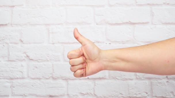 right hand showing like gesture against white brick wall background - Footage, Video