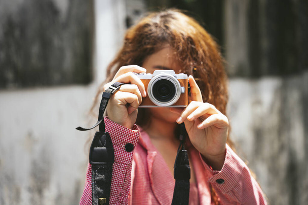 Close up portrait of young asian woman holding compact camera on street. - Photo, Image