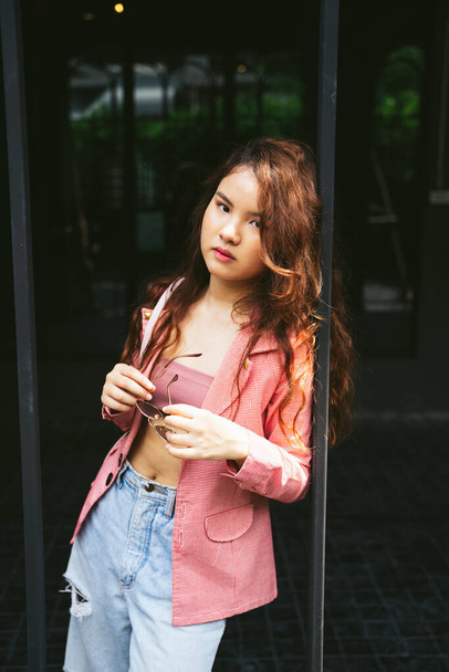 Retrato de moda de mujer asiática joven con chaqueta rosa apoyada en el espejo. - Foto, Imagen