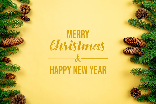 Christmas background, pine tree with xmas decoration on yellow background - Photo, Image