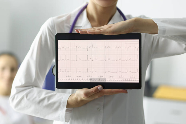 Lékař drží tablet s elektrokardiogramem na klinice detailní - Fotografie, Obrázek