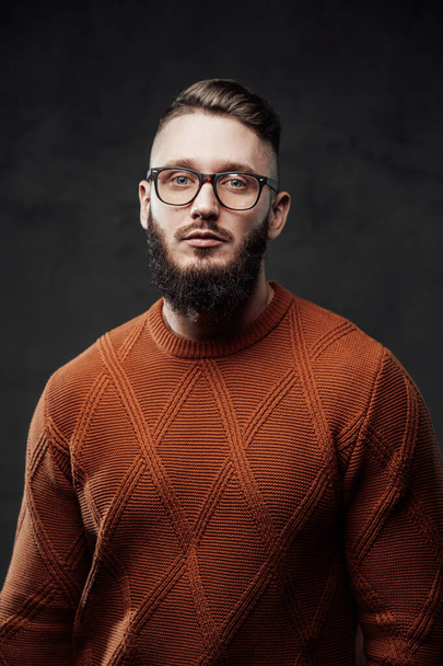 Confident and serious guy with beard in dark background - Fotó, kép