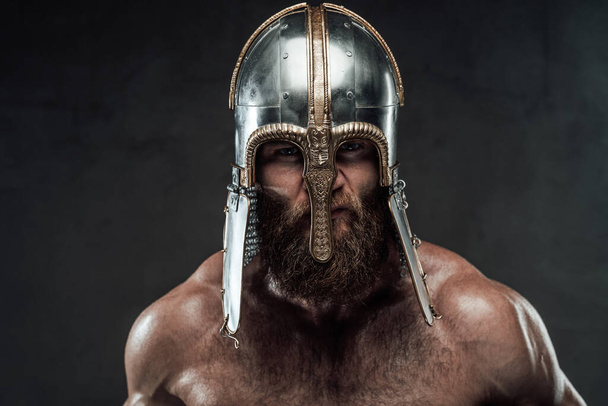 Aggressive viking with helmet on him in dark background - Photo, Image