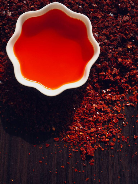 Aceite de chile rojo en cuenco de porcelana blanca, aceite de pimienta rad - Foto, imagen