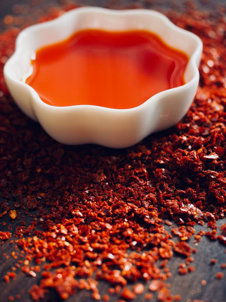 Punainen chili öljy valkoisessa posliinikulhossa, raju pippuriöljy - Valokuva, kuva