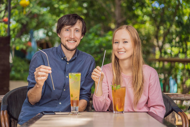 Eco friendly couple using reusable stainless steel straw to drink fruit tea - Φωτογραφία, εικόνα