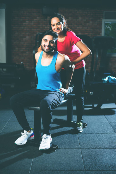 sporty indiano asiatico giovane coppia stretching in palestra post esercizio per il raffreddamento giù, migliorare la flessibilità - Foto, immagini