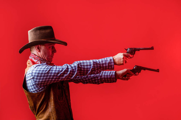 Miehellä on cowboy-hattu ja ase. Cowboyn muotokuva. West, aseet. Cowboyn muotokuva. Länsimainen hattupäinen mies. Muotokuva maanviljelijä tai cowboy hattu. Amerikkalainen viljelijä - Valokuva, kuva