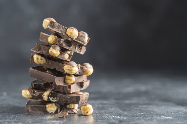 Pile chocolate with nuts on the gray background, close up - Foto, Bild