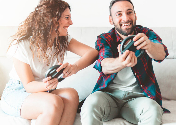Engaged couple has fun playing video games - lovers are joking while spending free time together - Photo, image