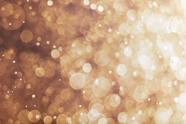 A gold background with glowing bokeh lights - Fotoğraf, Görsel