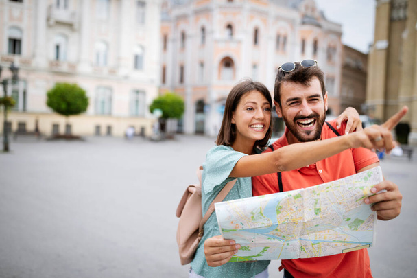 Happy couple on vacation having fun and sightseeing city with map - Fotoğraf, Görsel