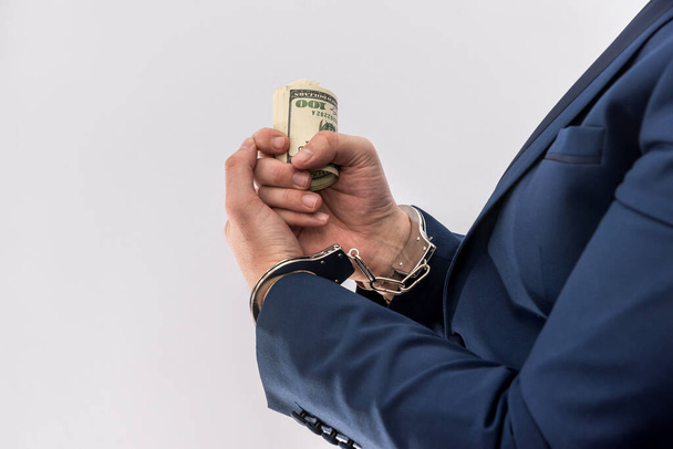 Lahjus tai korruptio käsite miesten käsissä pitää dollarin seteleitä käsiraudoissa. rikollinen - Valokuva, kuva