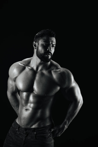 Γυμναστήριο αρσενικό μοντέλο στέκεται σε μαύρο φόντο - Φωτογραφία, εικόνα